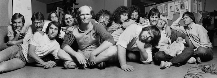 Panorama of the original Macintosh team, a group of  a little over a dozen men and women. Steve Jobs is pictured on the far right.