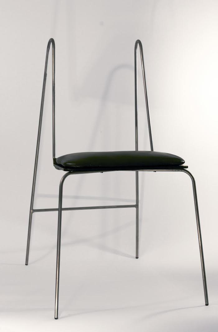 A chair with thin, clean, wiry legs and no back rest or padding.