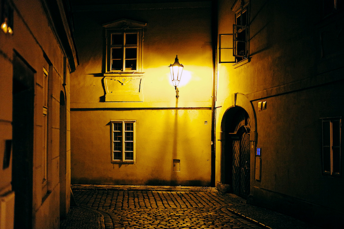 Gaslight illuminating an alley.