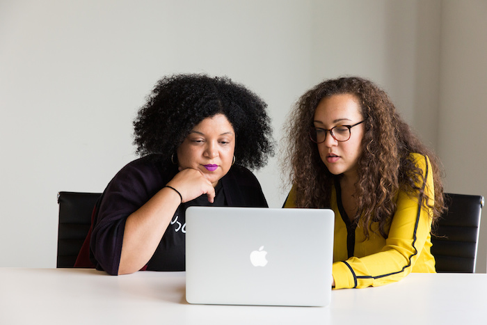 Two women collaborating on a computer.